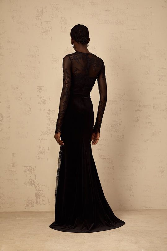 A black floorlength mermaid style dress with floral lace detailing named Ursula shown on a model against a plain background