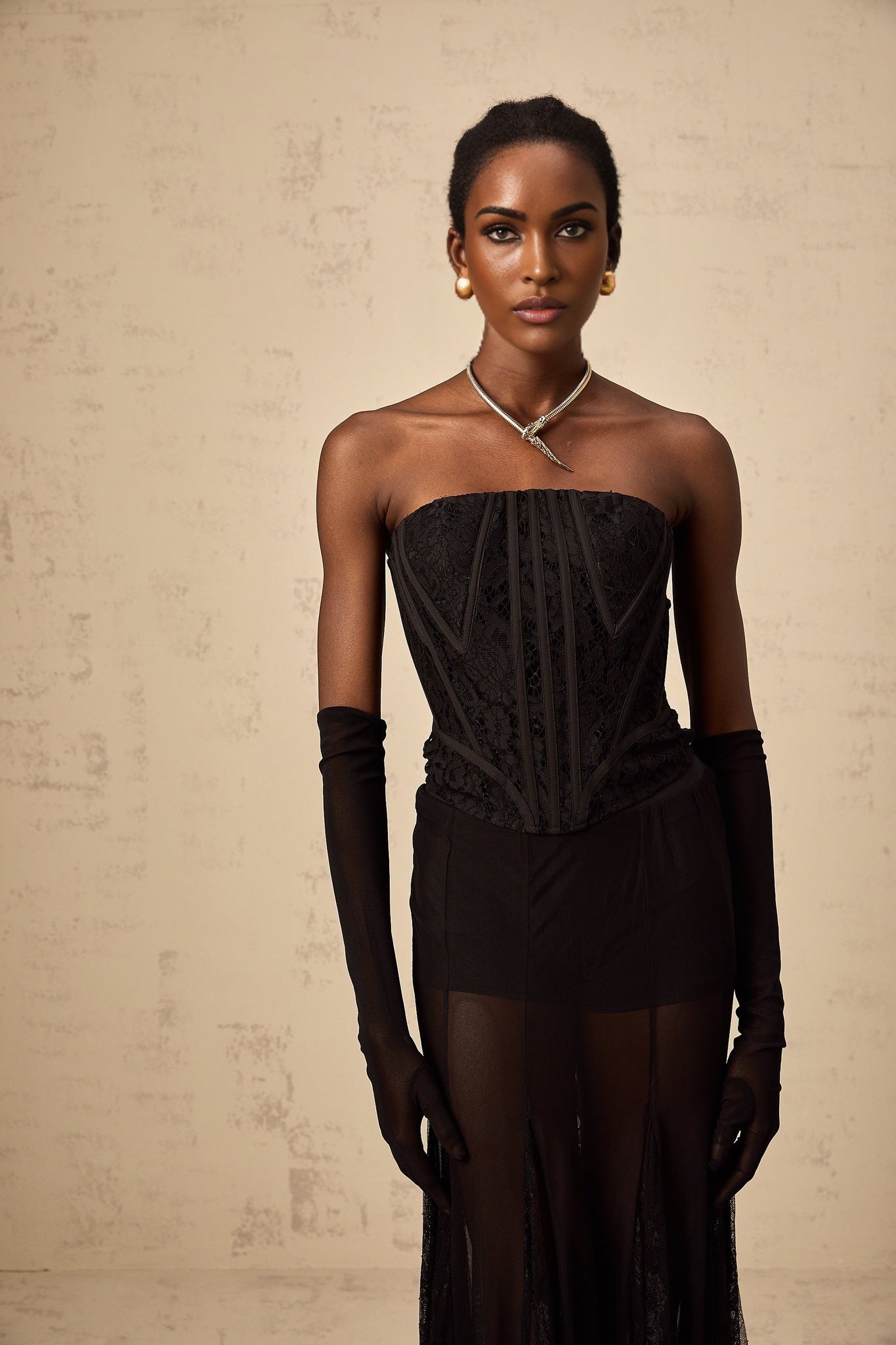 A black floral lace corset skirt and gloves set featuring delicate floral patterns on sheer fabric The ensemble includes a fitted corset top matching skirt and long gloves