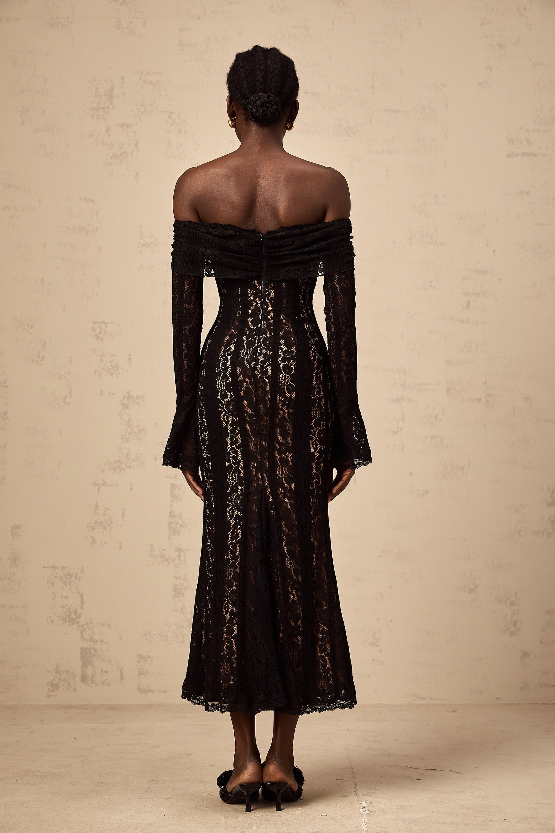 A black floral lace midi dress with flared cuffs named Emeline featuring an intricate floral pattern and a feminine silhouette