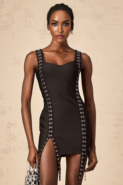 A black formfitting mini dress with hookandeye closures worn by a model standing against a plain background