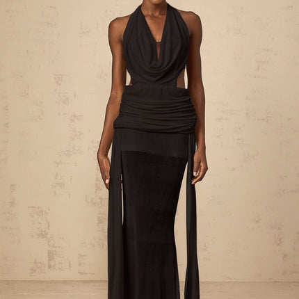 A black halterneck maxi dress with a backless design featuring a long flowing skirt and a tie at the neck