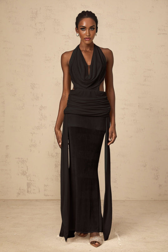A black halterneck maxi dress with a backless design featuring a long flowing skirt and a tie at the neck
