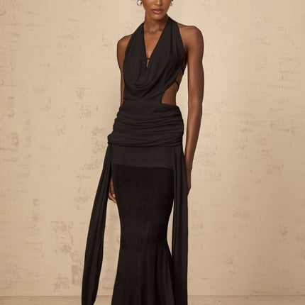 A black halterneck maxi dress with a backless design featuring a long flowing skirt and sleeveless style