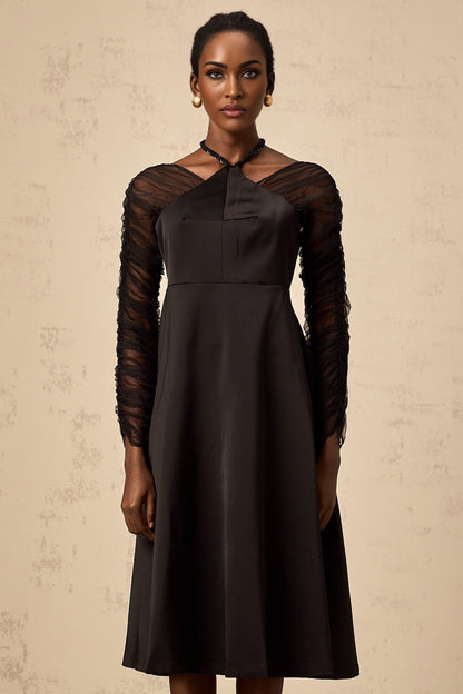 A black halterneck midi dress with panel detailing worn by a model against a plain background