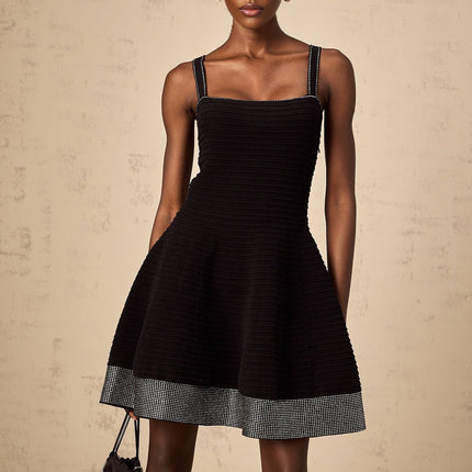 A black knit mini dress with a flared skirt and studded embellishments worn by a model