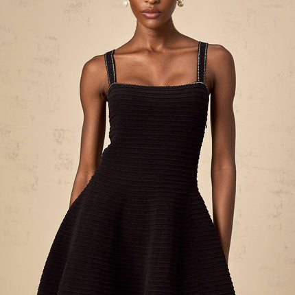 A black knit mini dress with flared skirt and studded details named Eliane