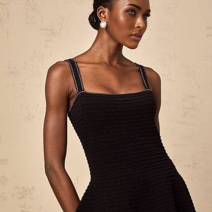 A black knit mini dress with flared skirt and studded embellishments called Eliane