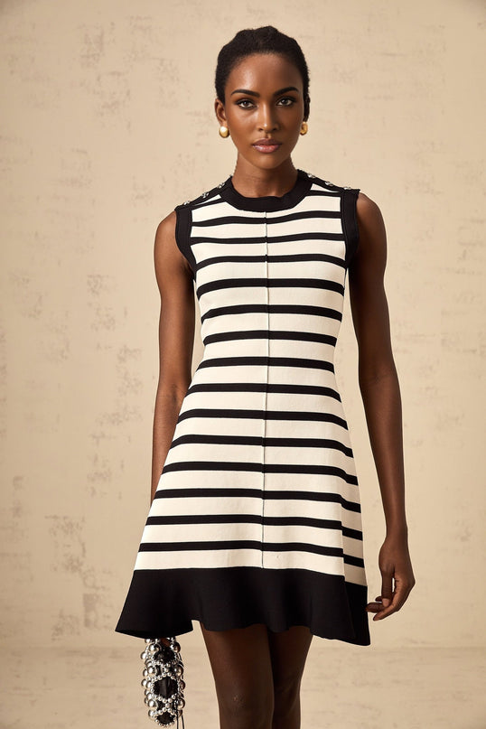 A black knit mini dress with horizontal stripes worn by a model standing against a plain background