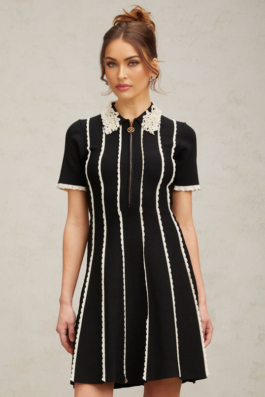 A black knit mini dress with vertical stripes and ruffle trim details named Zazie