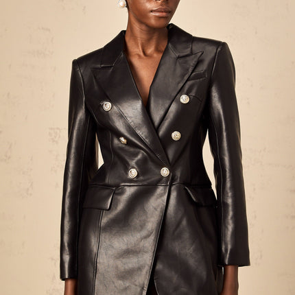 A black leather blazer mini dress featuring a tailored fit collar lapels and long sleeves styled as a short dress with a feminine silhouette