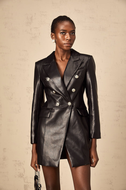 A black leather blazer mini dress with a fitted silhouette worn by a model against a plain background