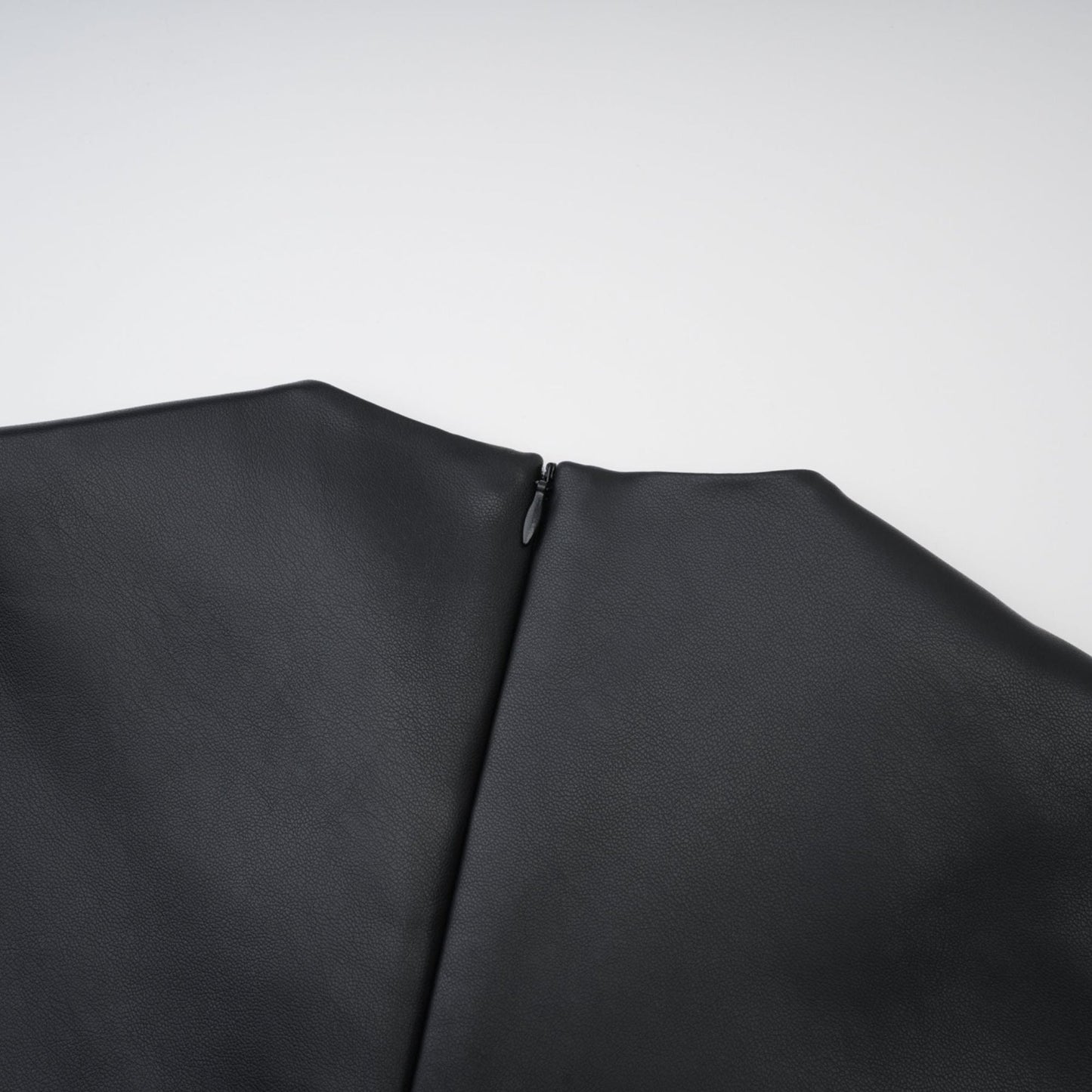Sleeveless black midi dress with round neck and leatherlike texture Hem is straight with rear zip fastening and front welt pockets %PU material offers durability