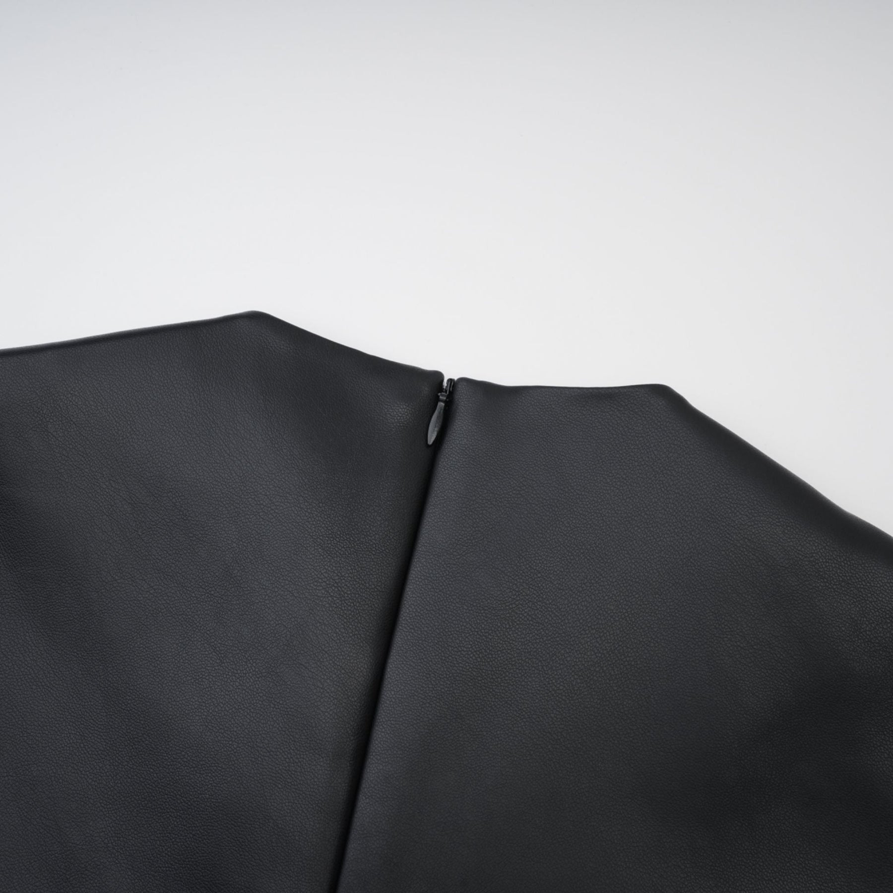 Sleeveless black midi dress with round neck and leatherlike texture Hem is straight with rear zip fastening and front welt pockets %PU material offers durability