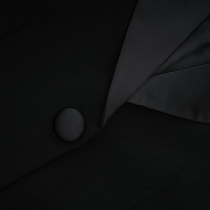 A black maxi dress with a blazerstyle top featuring embellishments and a long flowing skirt