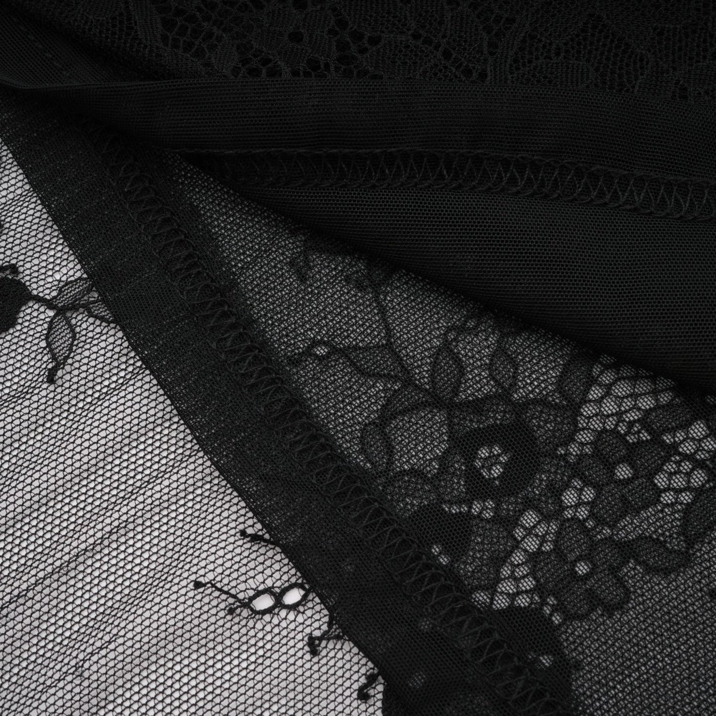A black lace dress with crystal embellishments and an asymmetric style
