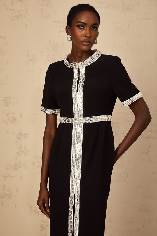 A black maxi dress with a front slit and crystal embellishments worn by a model standing against a plain background