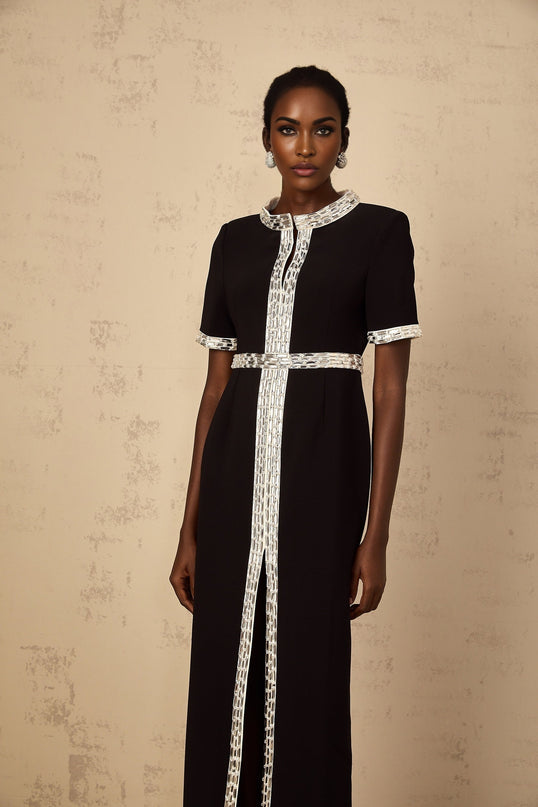 A black maxi dress with a front slit and crystal embellishments worn by a model