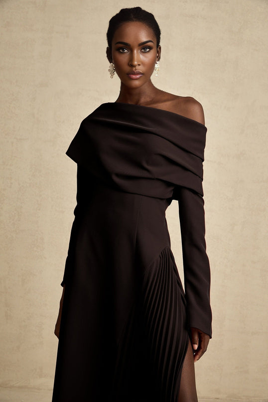 A black maxi dress with a high slit and pleated design suitable for Valentines Day featuring a long flowing skirt and elegant silhouette