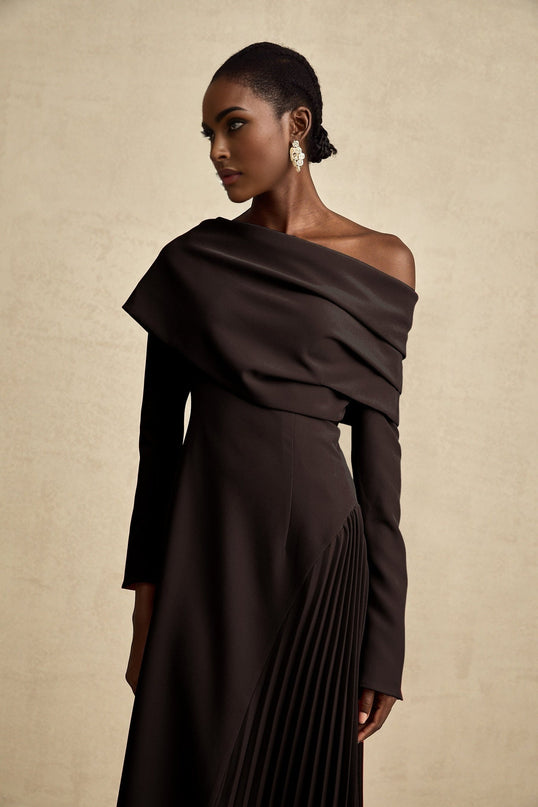 A black maxi dress with a high slit and pleated design suitable for Valentines Day featuring a long flowing skirt and elegant silhouette