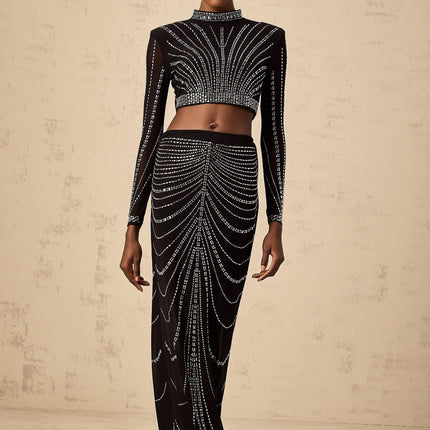 A black mesh twopiece outfit featuring a top and skirt adorned with rhinestone embellishments creating a sparkling effect on a sheer background