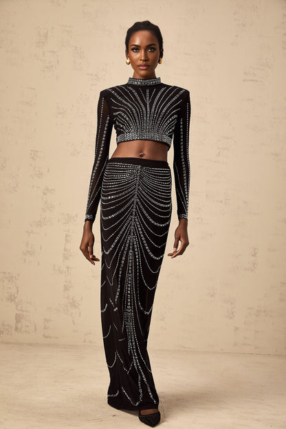 A black mesh twopiece outfit featuring a top and skirt adorned with rhinestone embellishments creating a sparkling effect on a sheer background