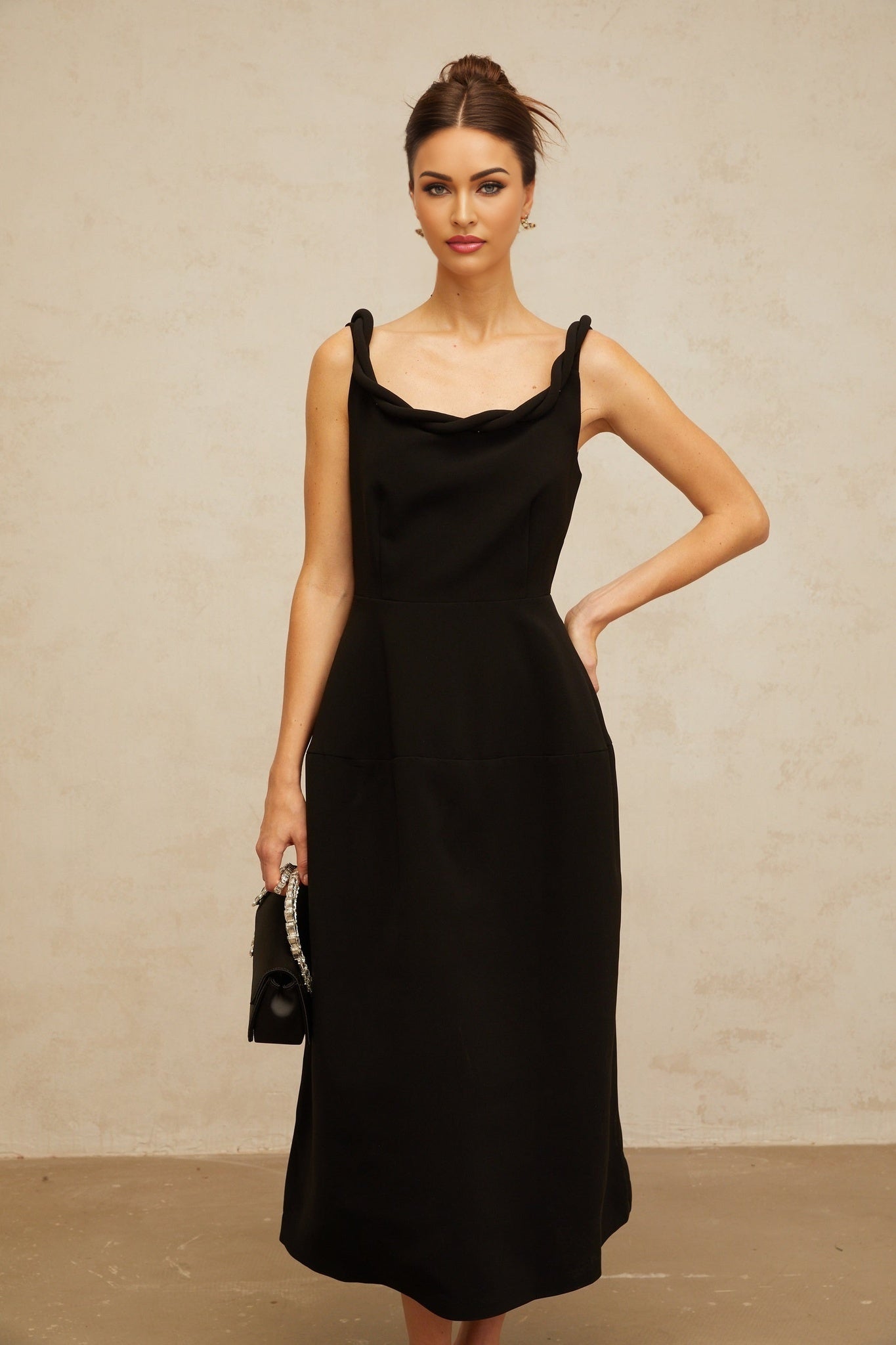 A black midi dress with a braided texture and puff sleeves featuring a fitted waist and flared skirt