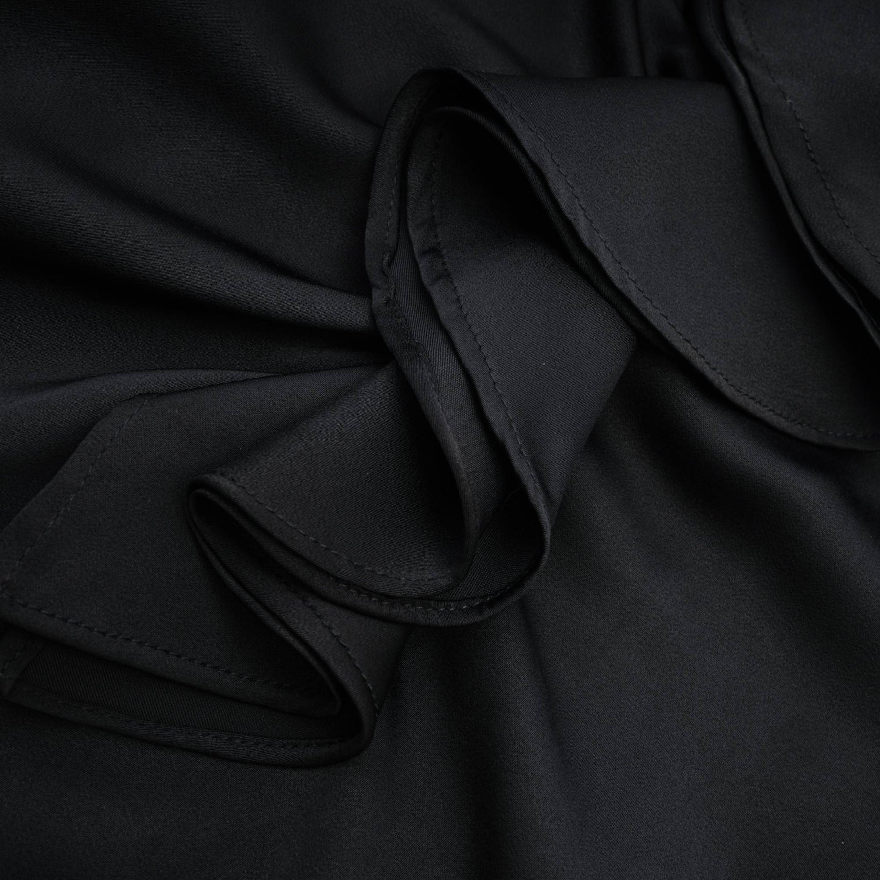 A sleeveless black dress with spaghetti straps flower decoration at the neck ankle length open back and made of 100% polyester