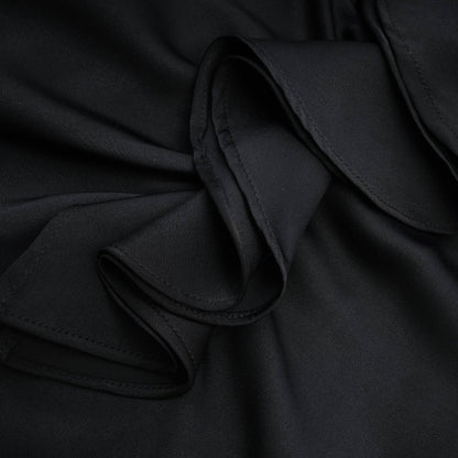 A sleeveless black dress with spaghetti straps flower decoration at the neck ankle length open back and made of 100% polyester
