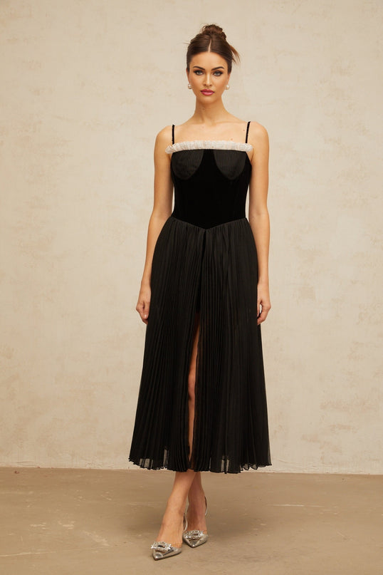 A black midi dress with a velvet panel and pleated skirt design named Clémence