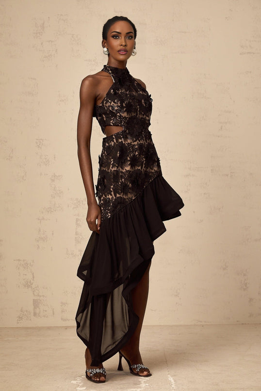 A black midi dress with an asymmetric hemline featuring floral applique details and the name Bernadette visible