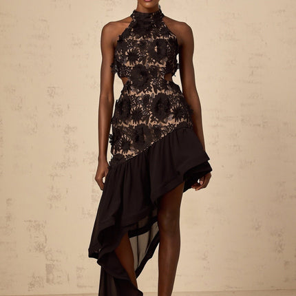A black midi dress with an asymmetric hemline featuring floral applique details named Bernadette