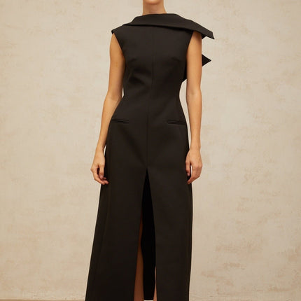 A black midi dress with an open back and deconstructed design featuring a woman wearing the Leonore dress