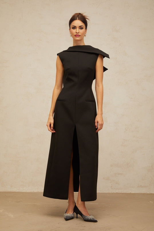 A black midi dress with an open back and deconstructed design featuring a woman wearing the Leonore dress