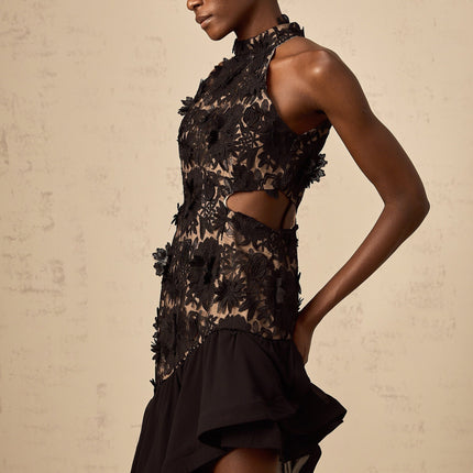 A black midi dress with asymmetric hemline featuring colorful floral applique detailing