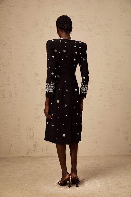 A black midi dress with dart details and embellishments designed by Gaelle