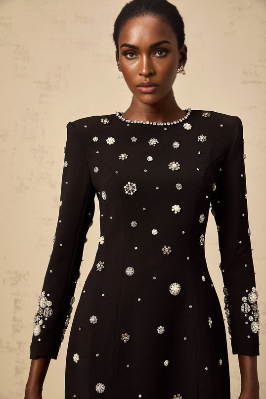A black midi dress with dart details and embellishments designed by Gaelle