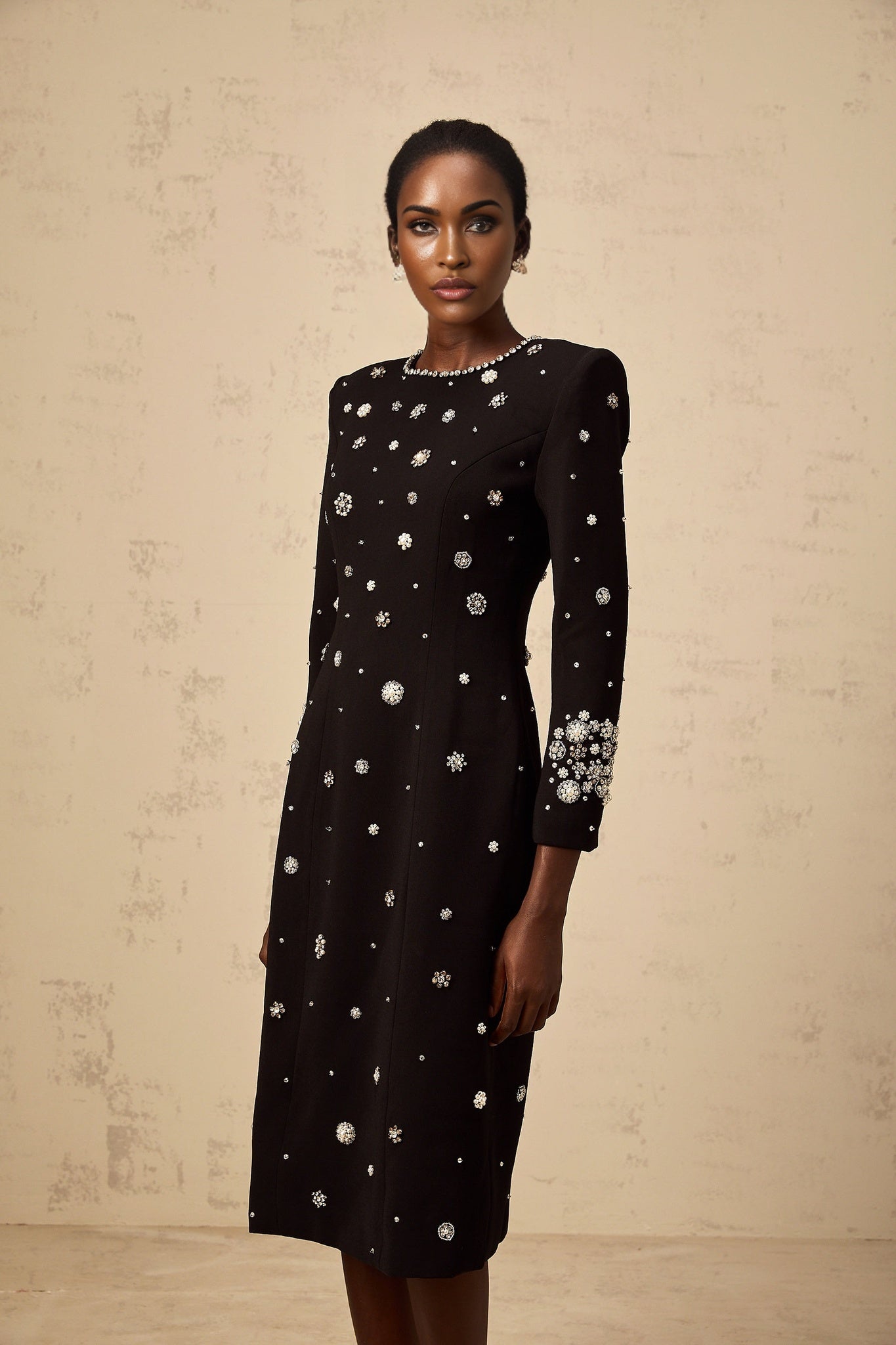 A black midi dress with dart details and embellishments designed by Gaelle
