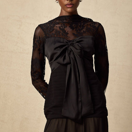 A black midi dress with floral lace panels named Amelie featuring a fitted silhouette and delicate floral patterns throughout the fabric