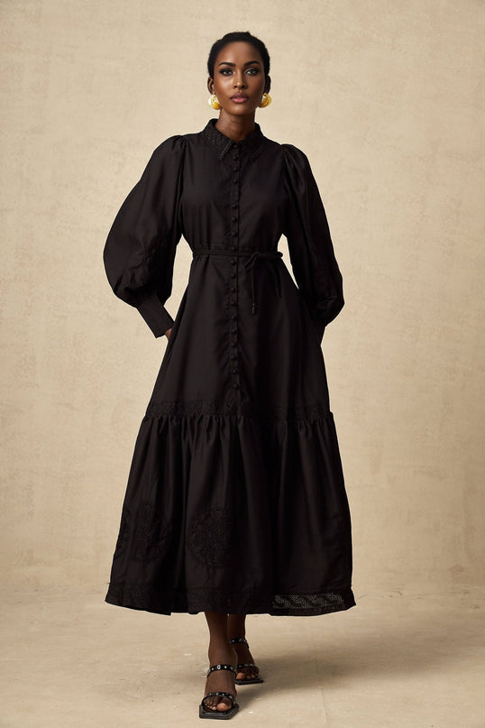 A black midi dress with lace embroidery details and a fitted silhouette