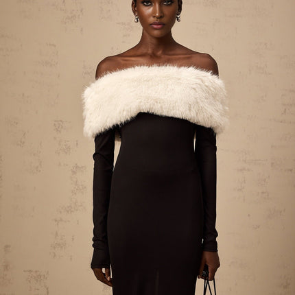 A black midi dress with offshoulder neckline and faux fur trim worn by a model standing against a plain background