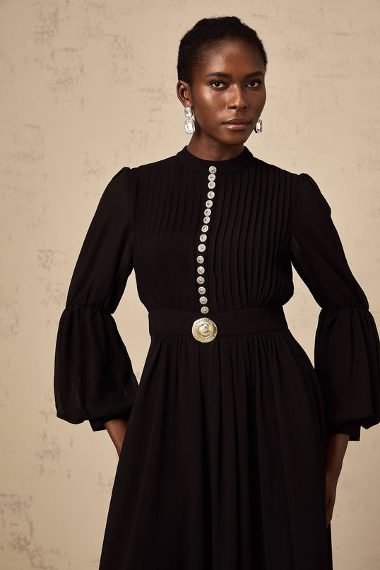 A black midi dress with pleated details and a buttonfront design featuring a fitted waist and flowy skirt