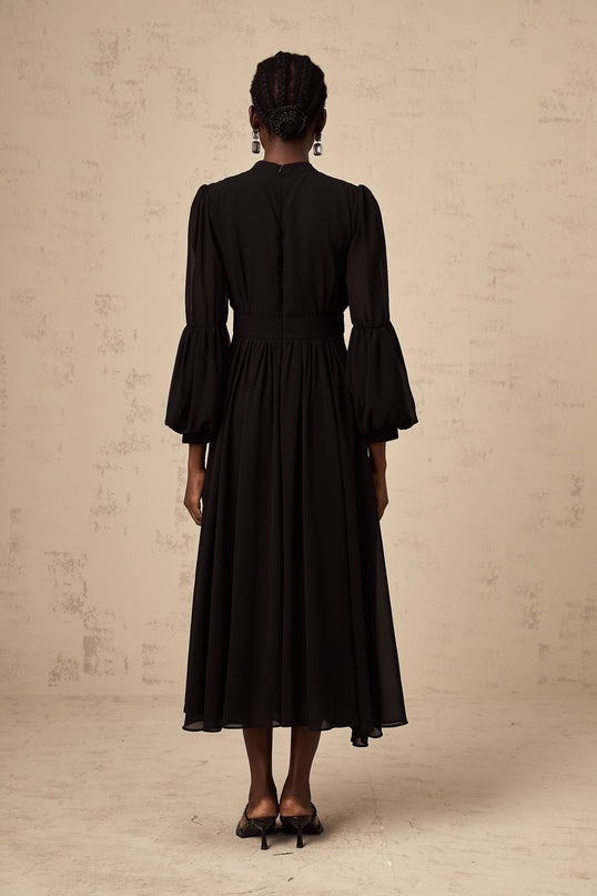 A black midi dress with pleated details and a buttonfront design featuring the name Viviane