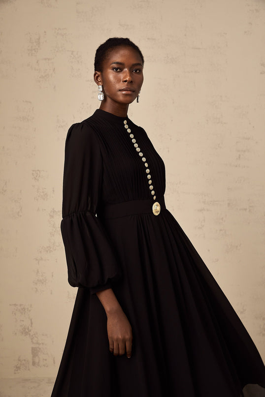 A black midi dress with pleats and a buttonfront design named Viviane