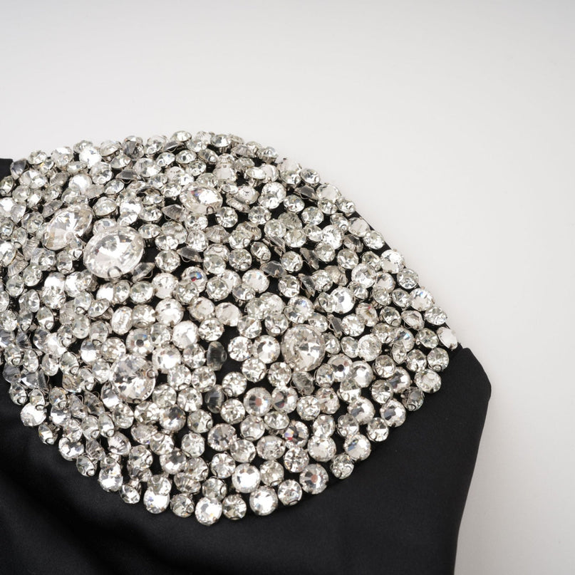 A black mini dress adorned with crystal embellishments featuring a short length and named Emmeline