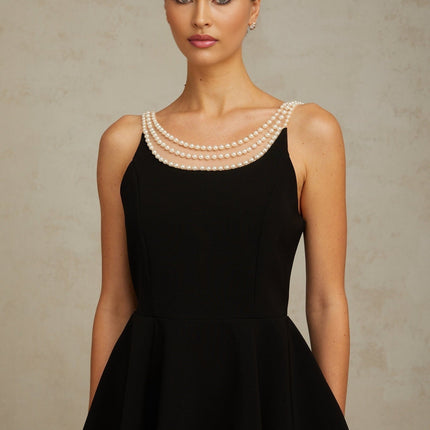 A black mini dress adorned with faux pearl embellishments called Danae