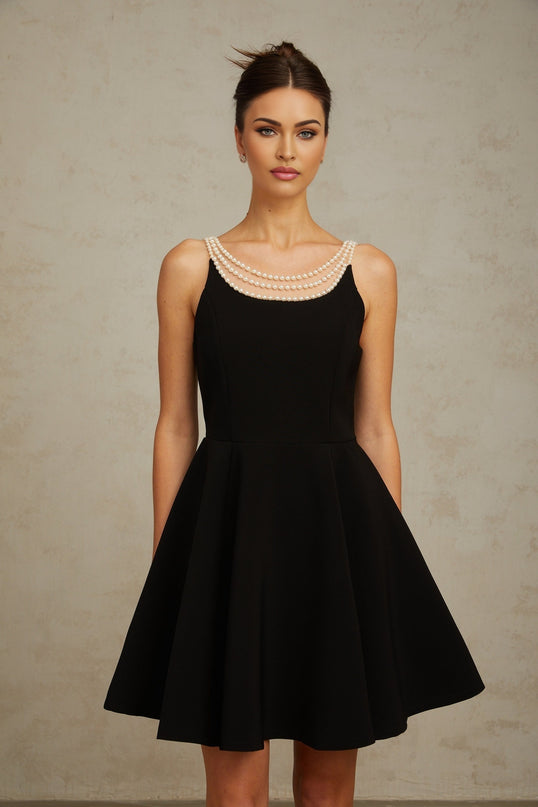 A black mini dress adorned with faux pearl embellishments named Danae