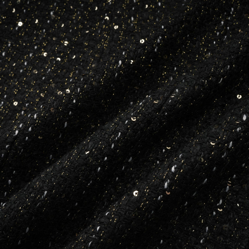 A black mini dress featuring a combination of tweed fabric and sequin panels named Audrey