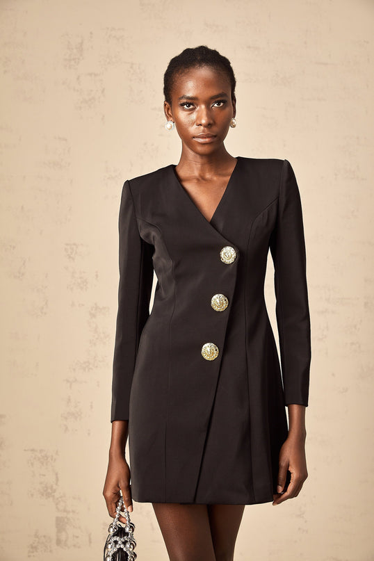 A black mini dress with a blazerstyle top featuring lion head embellishments on the front