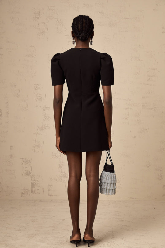 A black mini dress with a bowknot embellishment featuring a short hemline and fitted silhouette named Tania