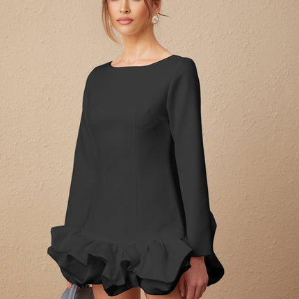 A black mini dress with a bubble skirt and fitted bodice worn by a model standing against a plain background